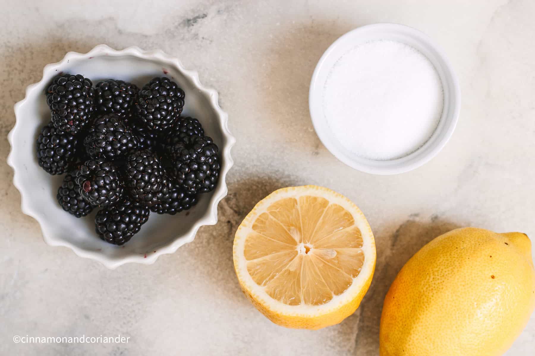 brombeeren, Zitronen und Zucker auf einer Marmorplatte