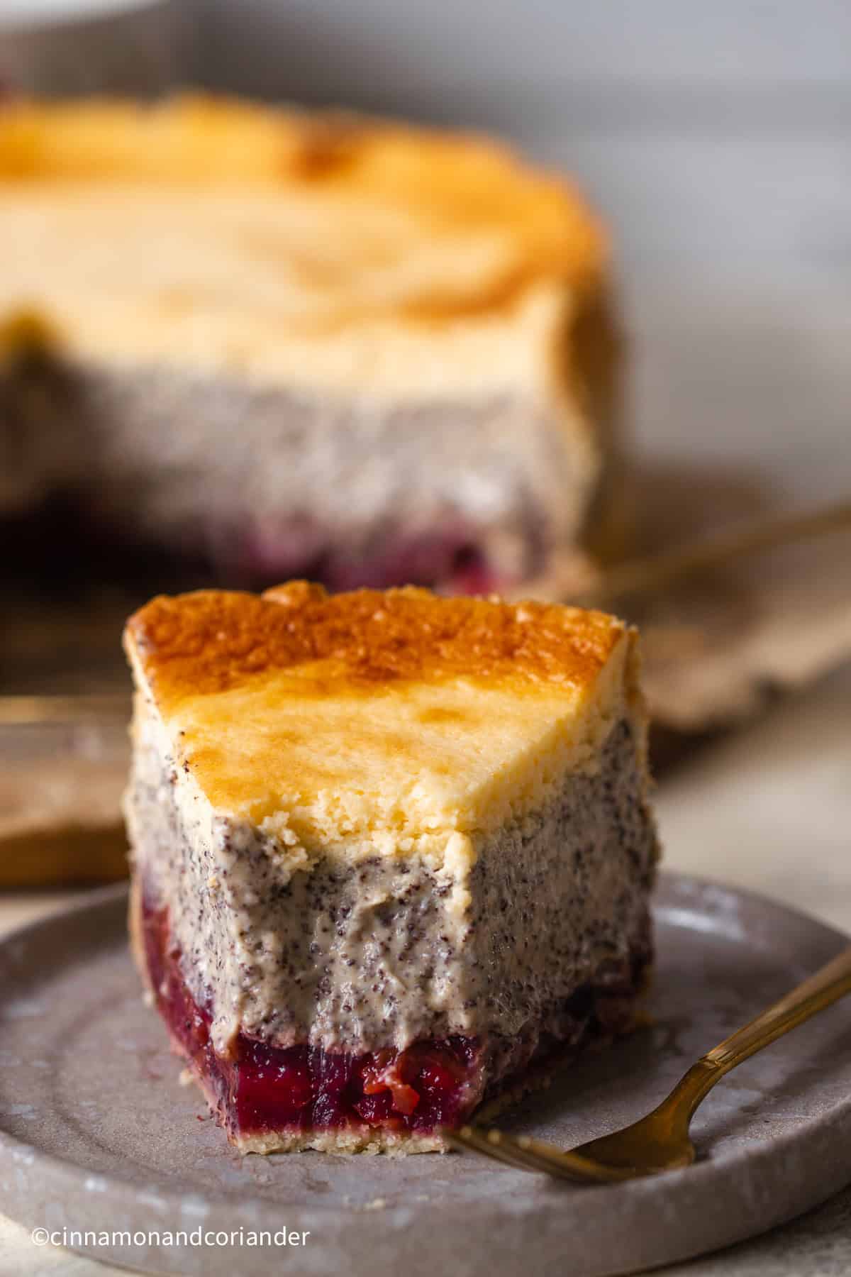 ein halb aufgegessener Mohn Kirschkuchen mit Schmandguss auf einem schwarzen Teller