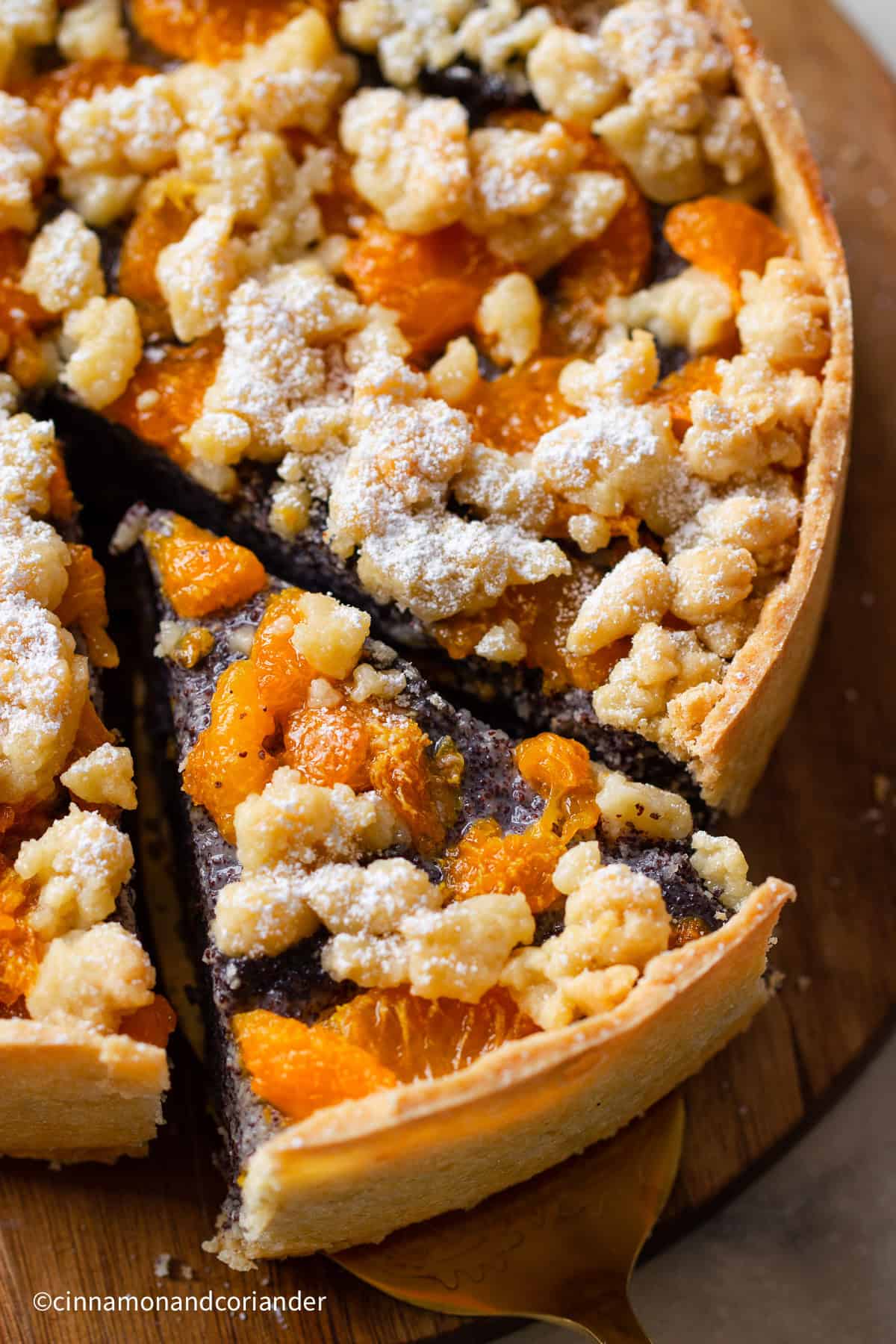 overhead shot of a sliced German poppy seed cake with mandarin oranges and streusel topping