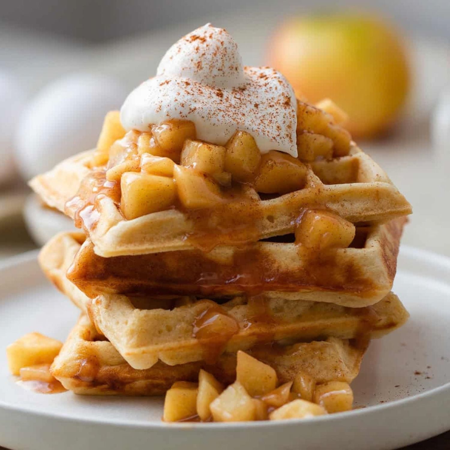 ein Stapel waffeln mit apfel topping und sahne