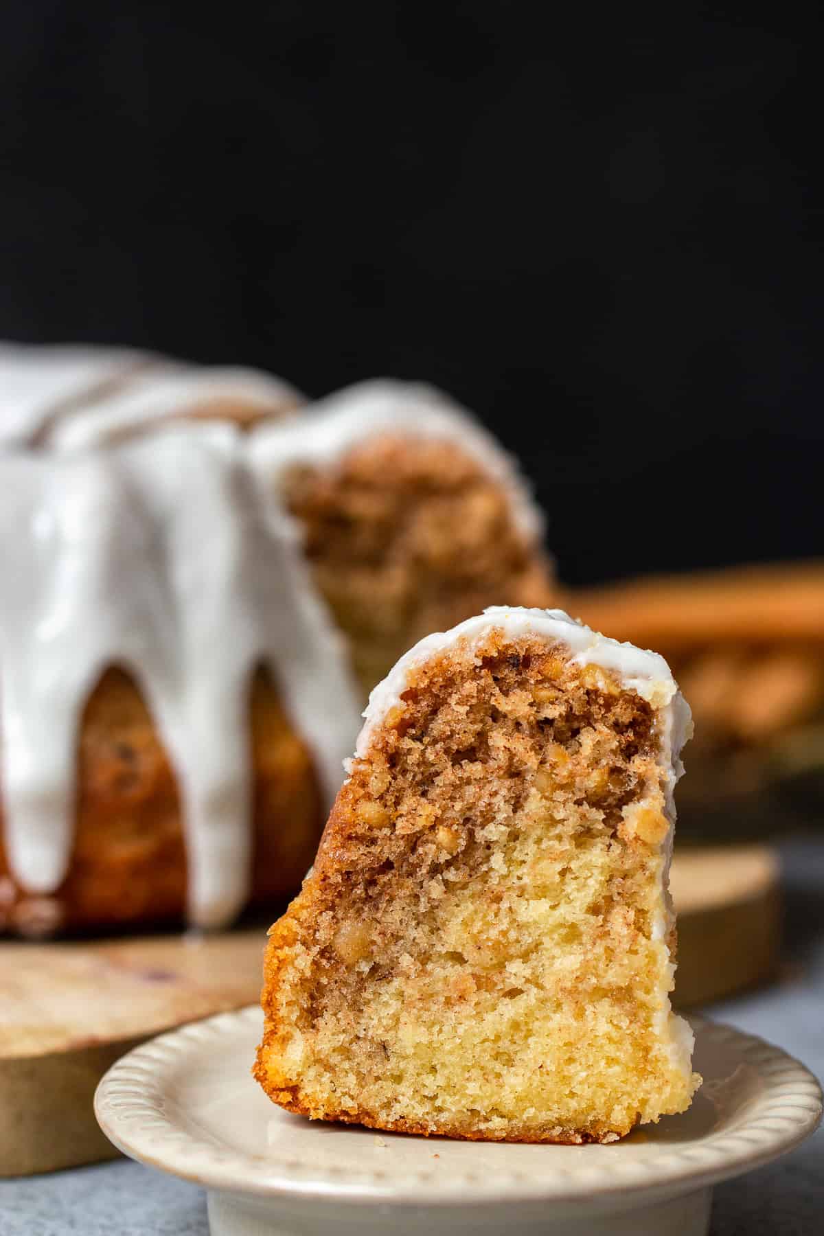 ein Stück Zimtschnecken Kuchen mit Zimt-Swirl, gerösteten Haselnüssen und Zuckerguss auf einem Dessert Teller