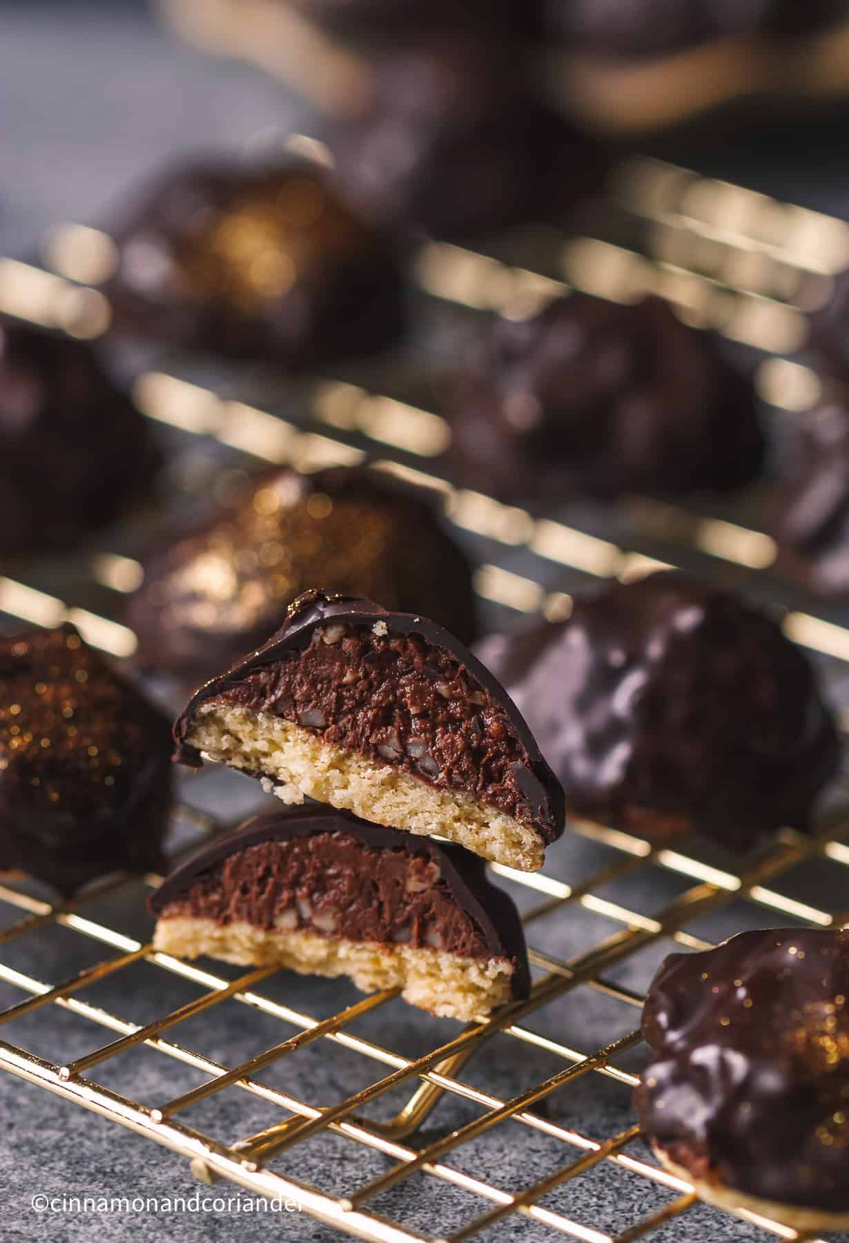 ein angeschnittenes Rocher Plätzchen mit Nougat auf einem goldenen Gitter